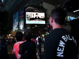 Peatones miran un monitor que muestra la noticia del anuncio de Carrie Lam en Hong Kong. AFP/A. Wallace