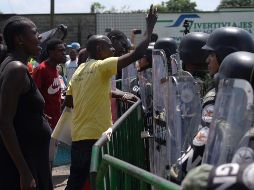 Migrantes de origen africano protestan frente a miembros de la Guardia Nacional en la garita migratoria Siglo XXI, en Tapachula. EFE/C. López