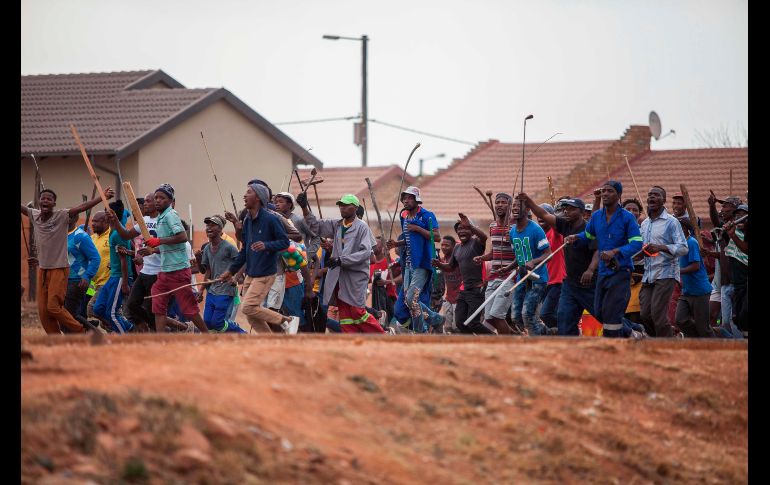 Una multitud armada con garrotes, palos y hachas se ve en el marco de los saqueos y disturbios en la zona.