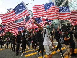Manifestantes ondean banderas estadounidense en su marcha al consulado de EU en Hong Kong. AFP/V. Prakash