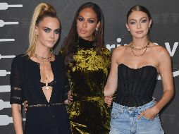 Cara Delevingne (L), Joan Smalls (C) y Gigi Hadid llegan a la pasarela de Savage X Fenty Show. AFP / A. Weiss