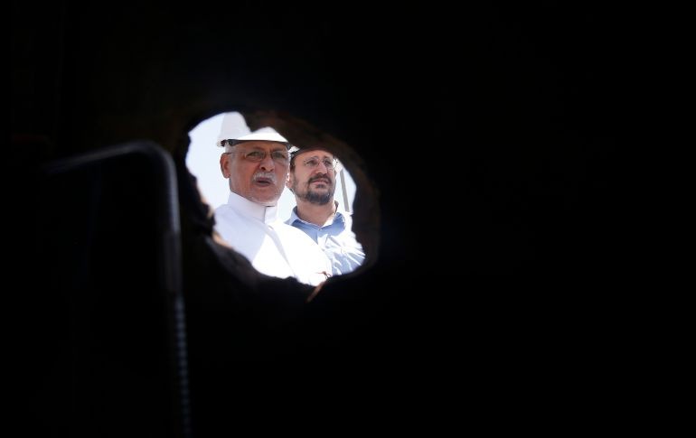 Trabajadores se ven a través del hoyo que en una pipa dañada en Khurais. AP/A. Nabil