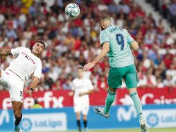 Karim Benzema cabecea hacia la portería del Sevilla para hacer el gol que puso al Real Madrid en la parte alta de LaLiga. AP