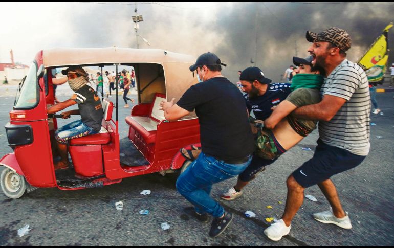 Manifestantes trasladan a un herido tras la refriega con las fuerzas del orden en la capital iraquí. AFP