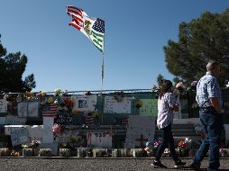 Varias personas caminan hoy frente al memorial instalado a las afueras de la tienda Walmart de El Paso, Texas. En el ataque del 3 de agosto murieron 22 personas.EFE/L. Torres