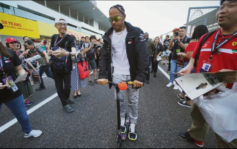 El piloto británico usa un scooter después de convivir con aficionados japoneses. AP