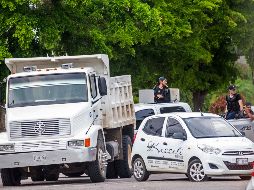 Hombres armados en el bloqueo a una calle ayer en Culiacán. AP/ARCHIVO