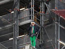 Tras subir sin protección por andamios instalados en Houses of Parliament, sede del parlamento británico, el militante disfrazado de Boris Johnson desplegó pancartas. AP/K. Wigglesworth