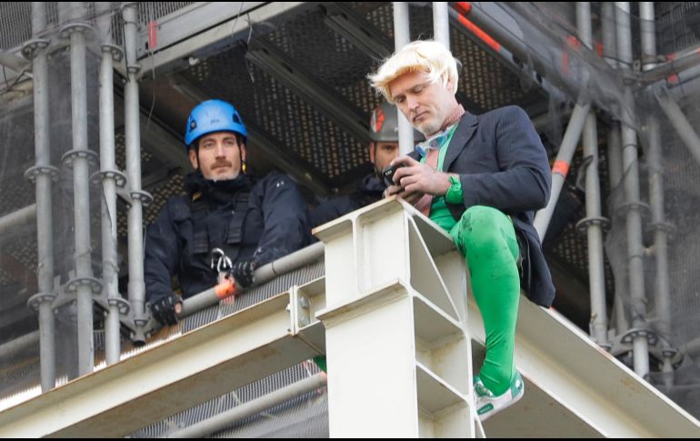Tras subir sin protección por andamios instalados en Houses of Parliament, sede del parlamento británico, el militante disfrazado de Boris Johnson desplegó pancartas. AP/K. Wigglesworth