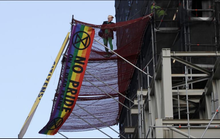 Tras subir sin protección por andamios instalados en Houses of Parliament, sede del parlamento británico, el militante disfrazado de Boris Johnson desplegó pancartas. AP/K. Wigglesworth