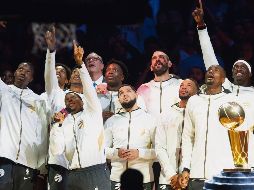 Previo al arranque del juego, jugadores de Toronto observan la develación del banderín de campeones. AP