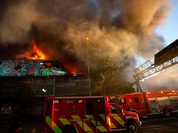 El fuego se propagó a dos altos edificios de oficinas colindantes, pero bomberos lograron evitar que las llamas se propagaran más allá. AFP/C. Reyes
