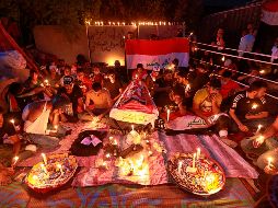 Habitantes oran junto a un ataúd simbólico por las víctimas mortales de las protestas en Bagdad. AP/H. Mizban