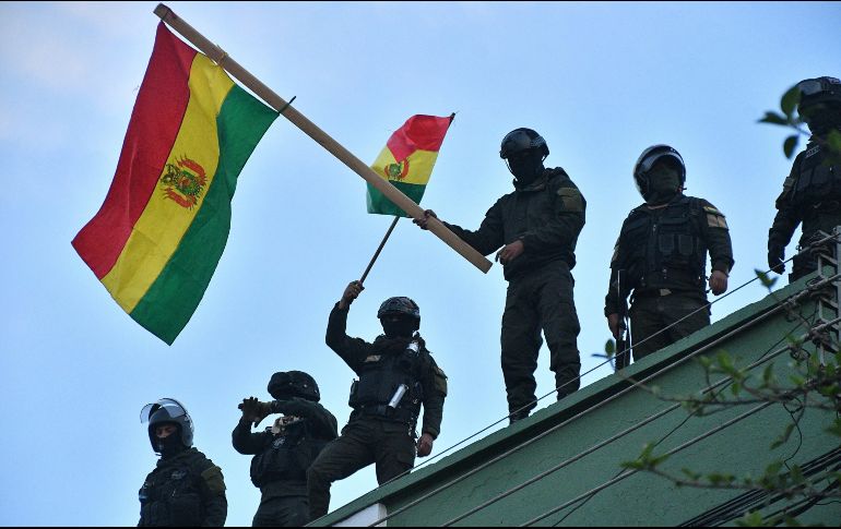 Uniformados bolivianos ondean banderas del país en el techo de una unidad policial este viernes en Cochabamba. EFE/J. Abrego