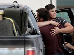 Cole Langford (i) y Hayden Spenct, de La Mora, en Sonora, se abrazan en un punto de reunión en Douglas, Arizona, a donde llegaron ayer. AP/Arizona Daily Star/K. Presnell