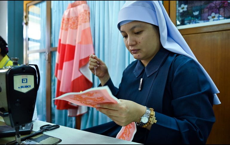 En una pequeña sala del convento, una decena de costureras trabajan incansablemente para unir telas de colores en seda artesanal, bajo la atenta mirada de la hermana Sukanya. AFP/R. Gacad