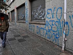 Un hombre pasa junto a una pinta contra Evo Morales, en La Paz. AFP/R. Schemidt
