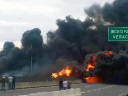 Curiosos observan cómo el fuego consume el vehículo cargado con combustible. ESPECIAL