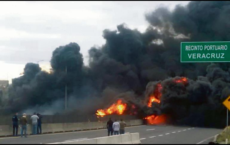 Curiosos observan cómo el fuego consume el vehículo cargado con combustible. ESPECIAL