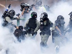 Policías antimotines se mueven entre una nube de gas lacrimógeno mientras detienen a un manifestante. AP//N. Han Guan