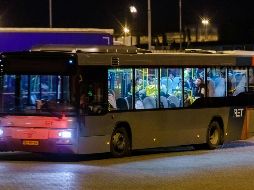 Un autobús con refugiados se aleja del buque tras el hallazgo, en el puerto de Vlaardingen, para trasladarlos a un centro médico. AFP/M. De Swart