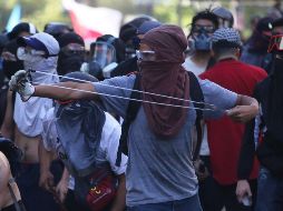 Manifestantes con gafas de protección se enfrenta a la policía antidisturbios. EFE/E. González