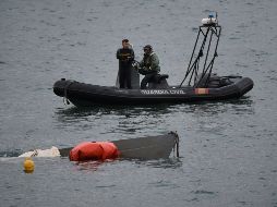 Buzos de la Guardia Civil laboran para reflotar el submarino localizado junto al puerto de Aldán, en la región de Galicia. AFP/M. Riopa