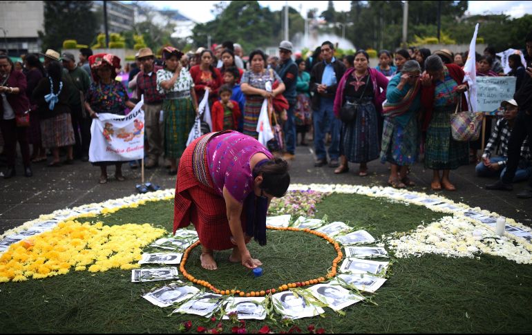 Organizaciones civiles colocan retratos de víctimas de las masacres del Ejército frente a la Corte Suprema de Justicia, en Guatemala. EFE/E. Bercián