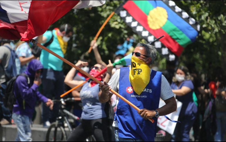 Grupos de personas pertenecientes a distintas gremios, sindicatos y organizaciones sociales participan en una marcha durante la huelga general este martes en Santiago. EFE/E. González