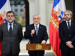 Piñera (c) urgió al Congreso para que despache proyectos de ley que establecen penas para los encapuchados, saqueadores y quienes levanten barricadas. AFP/J. Ordóñez