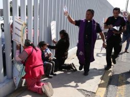 Mientras los sacerdotes rociaban sal y agua bendita, algunas personas se arrodillaron en el perímetro del inmueble para rezar. ESPECIAL