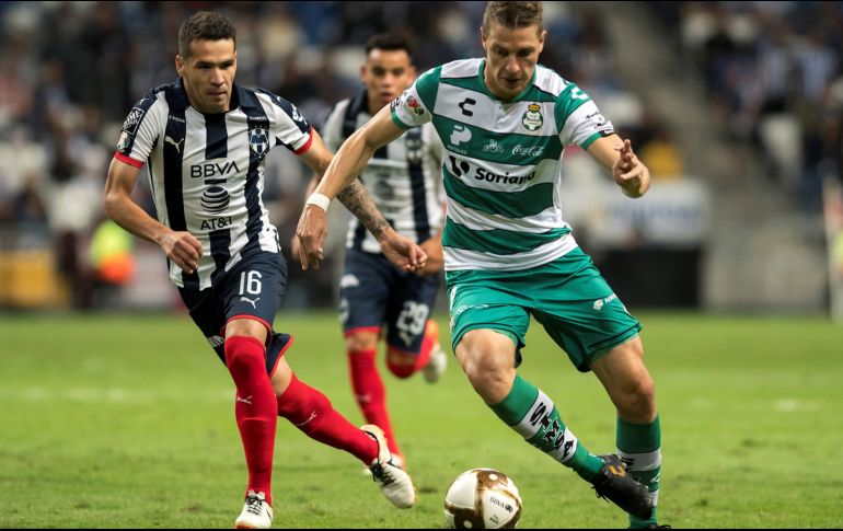 Celso Ortiz (i), de Rayados de Monterrey, disputa el balón con Julio Furch (d), de Santos Laguna, durante el encuentro de este jueves. EFE/M. Sierra