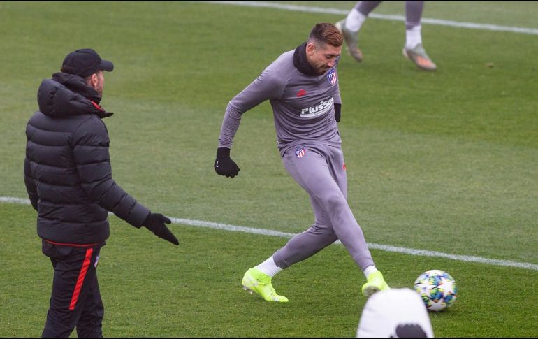Héctor Herrera toca el balón bajo la mirada del técnico Diego Simeone, durante la práctica de ayer previo al juego. EFE/R. Jiménez