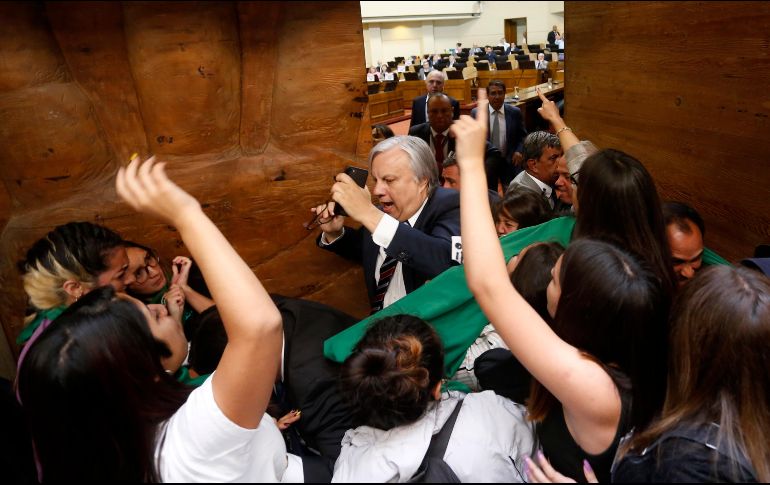 Un colectivo de feministas intentó entrar al recinto legislativo para exigir a diputados que consideraran la paridad de género en la constituyente. AFP/R. Zamora-ATON CHILE