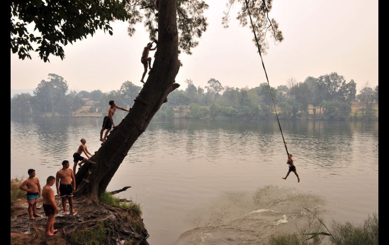 Jóvenes se lanzan al río Penrith durante la ola de calor en Sídney. AFP/F. Khan