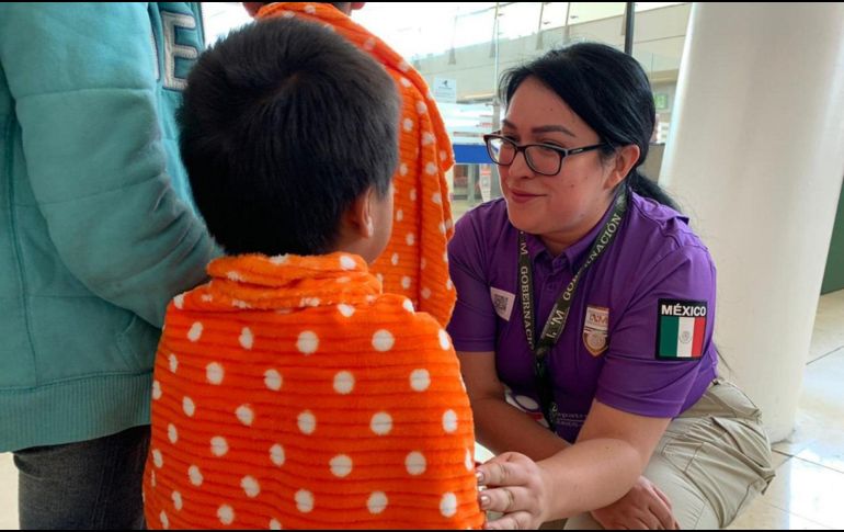 Empleada del INM recibe a migrantes en el aeropuerto de Guadalajara. En el primer vuelo llegaron 150 repatriados. EFE/INM