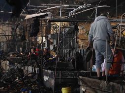 Locatarios del mercado de La Merced limpian y rescatan la mercancía que no se quemó luego del incendio registrado la noche de este 24 de diciembre. SUN/B. Fregoso
