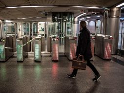 Un usuario del transporte público pasa delante de varios tornos bloqueados de la estación de tren de cercanías de Saint Lazare, en París. EFE/ C. Petit Tesson