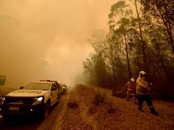 Bomberos combaten el fuego en Moruya, ciudad de la Costa Sur lejana de Nueva Gales del Sur. AFP/P. Parks
