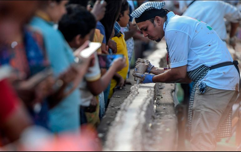 Unos mil 500 panaderos y reposteros necesitaron casi cuatro horas para armar el pastel, utilizando unas 12 toneladas de azúcar y harina. AFP/A. Sankar