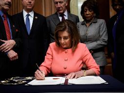 Nancy Pelosi firma los cargos para el juicio político contra Trump. AFP/B. Smialowski