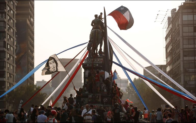 Manifestantes protestan en lo alto del monumento al general Manuel Baquedado, héroe de la guerra del Pacífico (1879-1884). EFE