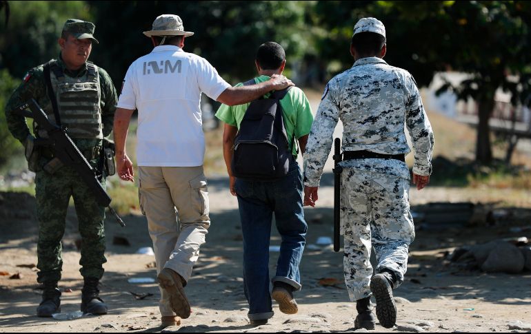 Un trabajador del Instituto Nacional de Migración escolta hoy a un migrante que cruzó a Ciudad Hidalgo, Chiapas, tras nadar por el río Suchiate. AP/M. Ugarte