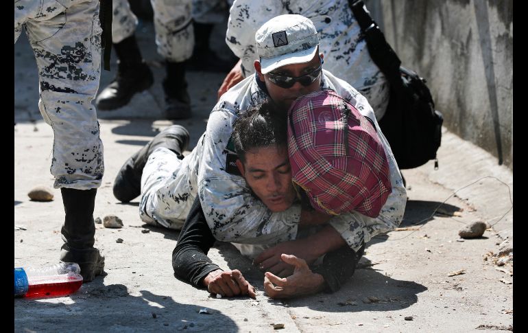 Un elemento de la GN detiene a un migrante que cruzó irregularmente. AP/M. Ugarte