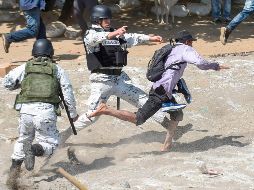 Elementos de la Guardia Nacional persiguen a un centroamericano que atravesó por el río. AFP/J. Ordonez