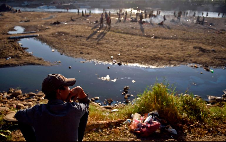 Un centroamericano descansa junto al Suchiate, del lado de Ciudad Hidalgo, Chiapas. Migrantes que cruzaron el río desde Guatemala pasaron ahí la noche en espera de que autoridades les permitan adentrarse por México. AFP/A. Estrella