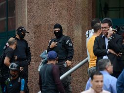 Oficiales de seguridad bloquean la entrada del edificio donde se encuentran las oficinas del líder opositor venezolano, Juan Guaidó, en Caracas. AP
