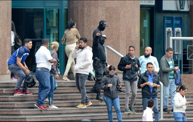 Oficiales de seguridad bloquean la entrada del edificio donde se encuentran las oficinas del líder opositor venezolano, Juan Guaidó, en Caracas. AP