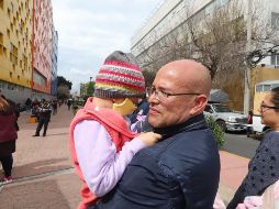 Uno de los padres con su pequeño enfermo, afuera del Hospital Infantil de México. NOTIMEX/G. Durán