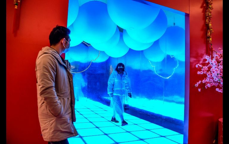 Personas llevan cubrebocas en un centro comercial. AFP/H. Retamal